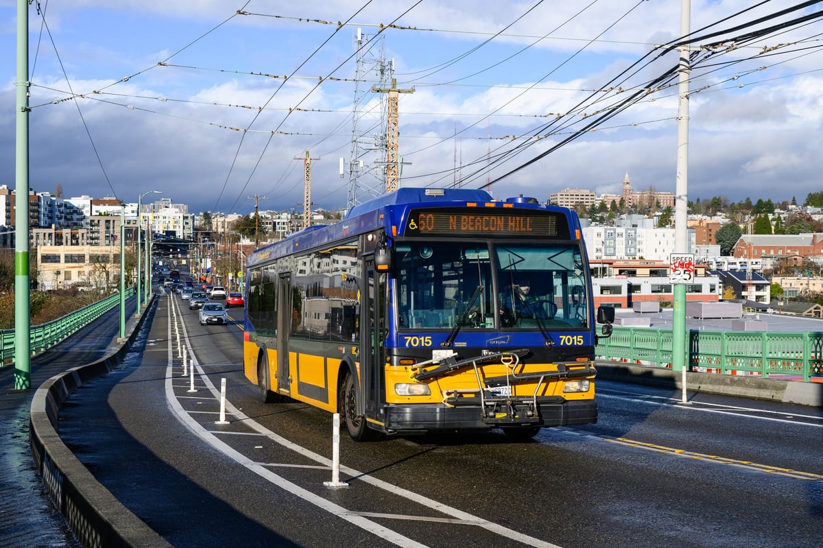 A modern Tahmeed Express coach bus navigating a city avenue, ready to take passengers on their journey